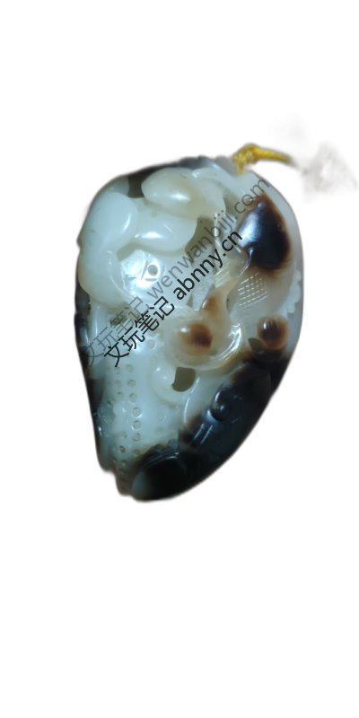 这是一件糖白玉俏色鱼形挂件。巧用玉料天然黑褐色泽，雕工精细，采用镂空技法，造型生动，寓意吉祥。鉴赏