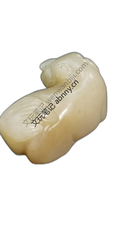 这件为玉雕瑞兽（似兔），呈蜷卧状。材质为带糖色青白玉，温润油润。采用圆雕工艺，线条圆润流畅，打磨精细光亮。收藏
